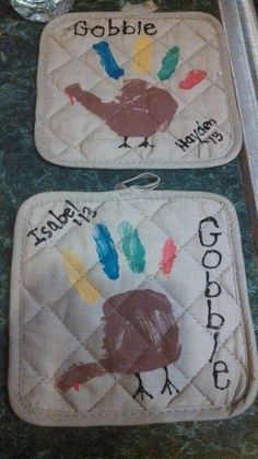 two oven mitts decorated with handprinted turkeys and words that read gobble