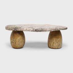 a marble and wood coffee table with two small legs on each side, sitting against a white background