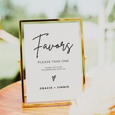 a sign that says favors on it sitting on top of a wooden table in front of a window