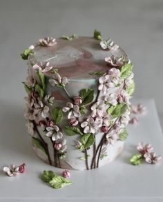 a cake decorated with pink flowers and green leaves