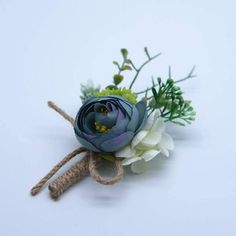 a boutonniere with white and blue flowers tied to it's side