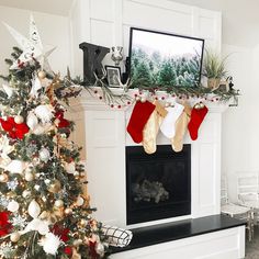 a christmas tree with stockings hanging from it in front of a fire place and fireplace