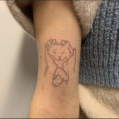 a small cat tattoo on the arm