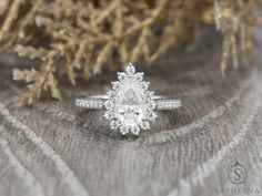 a diamond ring sitting on top of a piece of wood next to a tree branch