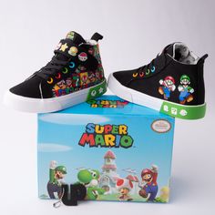 a pair of black and white shoes sitting on top of a box with an image of mario