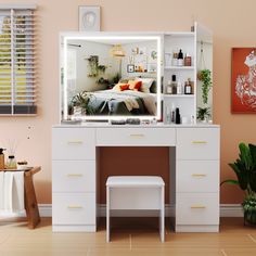 a white desk with a mirror on top of it next to a plant and potted plants