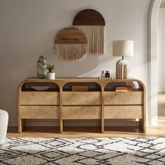 a living room area with a rug, table and two wall hangings on the wall