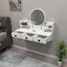 a white vanity with two drawers and a mirror on the wall next to a bed