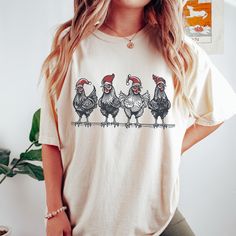 Christmas Chicken Shirt, Santa Hat Chicken T-Shirt, Funny Christmas Gift HOW TO ORDER Check and Review all Photos. Please check all size chart measurements ( width and length) before size decision.  Select Your T-Shirt Size and T-Shirt Color from drop down menus. Select Your Design- Print Color from images Write note on personalization your design selection and print color selection. Choose Your Quantity Tap ADD TO CART. And, you can go back to add more product color for your family members or Y White Christmas Tops With Funny Print, Christmas White Tops With Funny Print, White Top With Funny Christmas Print, White Christmas Top With Funny Print, Casual Christmas T-shirt With Relaxed Fit, Relaxed Fit Short Sleeve T-shirt For Holiday, Casual Relaxed Fit T-shirt For Christmas, Holiday Cotton T-shirt Pre-shrunk, Holiday Tops With Funny Print And Short Sleeves