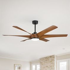 a ceiling fan in a living room with white walls and wood trimmings on the ceiling