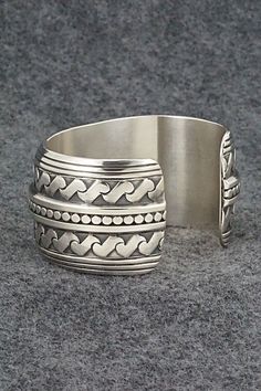 This stunning sterling silver bracelet was made by Navajo silversmith Raymond Delgarito. The back is signed RD and stamped sterling.Size: 5 1/4" (will fit up to a 6 1/4" wrist)Gap: 1"Width: 1 1/4"Free shipping on all orders! We ship with USPS and always include tracking. All orders ship within a day of payment.Returns are accepted up to 30 days after you receive your order. Just send us a message. Our shop offers cash back or store credit. The item must be returned in new condition. Bohemian Wide Band Jewelry Stamped 925, Adjustable Silver Southwestern Bracelet, Bohemian Wide Band Engraved Jewelry, Handmade Sterling Silver Cuff Bracelet Collectible, Southwestern Silver Bangle Jewelry, Handmade Sterling Silver Cuff Bracelet For Collectors, Southwestern Sterling Silver Bracelet Stamped 925 As Gift, Southwestern Style Silver Round Cuff Bracelet, Handmade Sterling Silver Collectible Bracelet