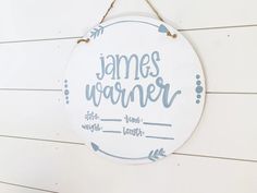 a white sign hanging on the side of a wooden wall that says, james warmer