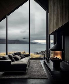 a living room with large windows and a couch in front of the window looking out onto the ocean