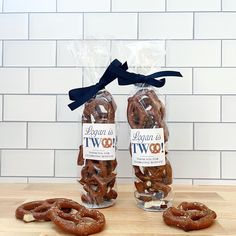 two bags of pretzels sitting next to each other on a wooden counter top