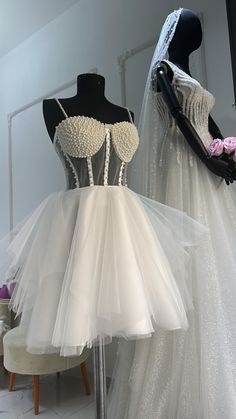 two mannequins dressed in white dresses on display at a bridal event