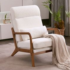 a living room with a chair, rug and potted plant