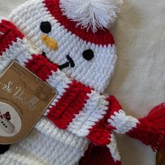 a crocheted snowman hat and scarf with a tag on the bottom that says, it's cold outside