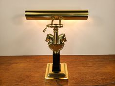 a golden desk lamp with a horse head on it's base and a gold shade