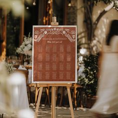 a wooden easel with a wedding seating plan on it in front of a restaurant