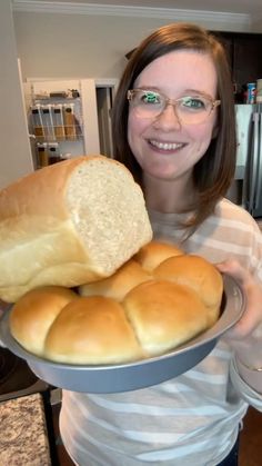 a woman holding a plate with bread on it