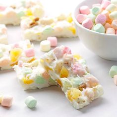 some marshmallows are next to a bowl of candy