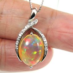 Fine hand-crafted solid platinum (Pt.900) pendant with 0.07ctw. of sparkling natural mined accent diamonds and a large 3.676ct. of  Ethiopian flashy 'harlequin", untreated "fire opal". So striking rolling flashed of rainbow colors (red, green, blue, orange gold; etc.). The necklace is also made of platinum (stamped: Pt850).  It is fine, dainty necklace, which about 0.7mm in thickness & 17.5 inches in length and can be adjust to shorten it. Style: Pendant Necklace Precious Metal: Solid Platinum (PT900) Genuine diamond: 0.07ctw. Pendant Size (L x W):  13.5mm x 25.8mm Necklace Length: 17.5 inches & adjustable. Total Weight (includes chain): 8.7 grams. Opal Type: Welo Opal. Size: 9.5 x 13.8mm Weight: 3.676ct. Color:   Beautiful array of color spectrum. Treatment: Natural (untreated). Origin: E Platinum Oval Necklace As Gift, Platinum Oval Necklace For Gifting, Platinum Oval Necklace For Gift, Platinum Oval Necklaces For Gifts, Platinum Drop Jewelry Gift, Platinum Pendant, Box Chain Necklace, Welo Opal, Orange Gold