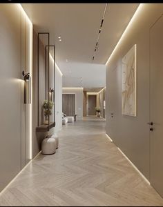 an empty hallway with white walls and wood flooring is lit by recessed lighting