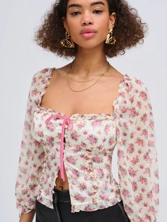 Explore a world of delicate hues and charming flower patterns with the Etienne pink top—a dainty floral blouse with three-quarter chiffon sleeves and ruffle accents made of satin. This vintage-inspired design also boasts a shirred bodice and a whimsical decorative bow at the center. The Etienne Top is designed to be fitted and fits true to size. Style Notes Lined bust panel Elasticized puff sleeves Functional button placket and tie at the center-front Non-functional ties at the elasticated sleev Romantic Tops, Chiffon Sleeves, Three Quarter Sleeve Tops, Sweater Crop, Floral Outfit, For Love & Lemons, Crop Top Sweater, Little White Dresses, Love And Lemons