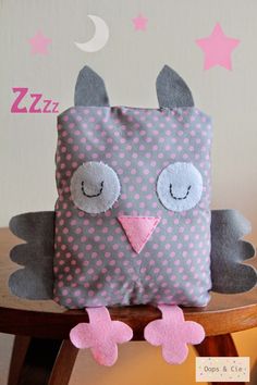 a stuffed owl sitting on top of a wooden chair next to a wall with stars