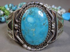 "Item Details 1970s Native American silver art. Photos are part of the item description. Listing is for bracelet only. Coin and Background decor not included.TY~. Unsigned Old Pawn. Guaranteed Solid Sterling silver. Genuine Arizona Ithaca Peak Turquoise. 35mm x 24mm size gemstone, PERFECT! Cuff is 2\" high/wide at front peak, 9/16\" at ends. Cuff measures 5&1/2\" from end to end on inside. Separate 1&1/4\" gap. Currently sized at 6&3/4\" wrist. Size is adjustable. Best for wrist sizes; 6&1/4\" t Unique Turquoise Bracelet, Unique Turquoise Bracelets Collectible, Retro Turquoise Jewelry For Collectible, Vintage Turquoise Bracelets As Gift, Retro Turquoise Jewelry Collectible, Retro Turquoise Jewelry For Collectors, Vintage Turquoise Bangle As A Gift, Southwestern Blue Cuff Bracelet With Patina, Antique Turquoise Cuff Bracelet As Gift