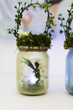 two vases with plants in them sitting on a table