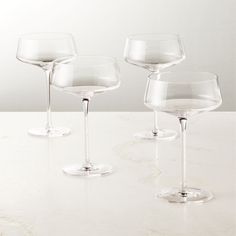 three empty wine glasses sitting on top of a table