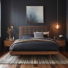 a bedroom with black walls and wooden floors, an upholstered bed, two hanging lights, and a large painting on the wall