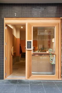 the front entrance to an office building with glass doors and wooden trimmings on the windows