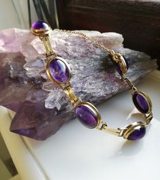 "A sumptuous antique Art Deco bracelet, housing the most beautifully intense cabochons of amethyst. Most probably created in the 1920s era in Germany, as 8ct gold (often stamped \"333\" as in this case) was used there quite a lot in the first decades of the twentieth century. It screams the Art Deco designs of the era, both in its use of those parallel strips of gold as connectors between each large cabochon and also its use of purple in these wonderful stones. I love this bracelet- it wears so Formal Amethyst Oval Cabochon Jewelry, Formal Amethyst Jewelry, Oval Cabochon, Oval Cabochon Bracelets For Formal Occasions, Classic Oval Cabochon Amethyst Jewelry, Classic Amethyst Cabochon Jewelry, Formal Purple Oval Cabochon Jewelry, Antique Oval Gemstone Bracelets, Classic Amethyst Purple Bracelets, Classic Amethyst Bracelets In Purple