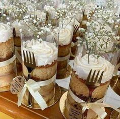 there are many desserts on the table with forks in each cupcake, which is decorated with baby's breath flowers