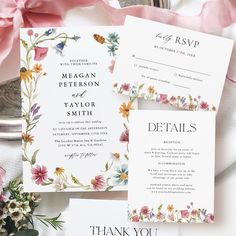 the wedding stationery is laid out with flowers