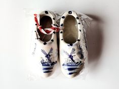 a pair of white shoes with blue and red designs on them sitting in a plastic bag