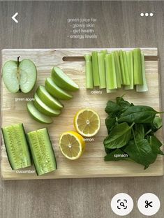 a cutting board topped with sliced up green apples and cucumber next to slices of lemon