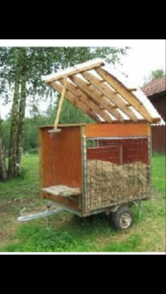 a horse trailer with hay in it and a roof made out of wooden planks