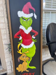 a christmas sign with the grinch and dog in santa's hat on it