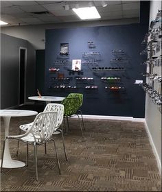 an office with tables and chairs in front of a wall that has pictures on it