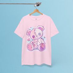 ✦ OUR PRODUCT Embrace your soft side with a hint of edge in this Stitched Teddy Bear t-shirt! Featuring an adorable pastel-colored teddy bear with stitched details and cute little hearts, this design brings a perfect blend of sweet and quirky vibes. Made from durable 100% US cotton, this unisex t-shirt is comfortable for everyday wear while standing out with its playful, pastel goth style. Whether you're into cute designs or alternative fashion, this tee adds a unique, whimsical touch to your wa Pink Cotton Emo T-shirt, Kawaii Anime Print T-shirt For Streetwear, Pastel Goth Short Sleeve T-shirt For Streetwear, Pastel Goth Cotton T-shirt With Graphic Print, Pink Emo Style Cotton T-shirt, Emo T-shirt With Character Print, Pink Short Sleeve Emo Tops, Kawaii Cotton T-shirt With Anime Print, Kawaii Anime Print Cotton T-shirt