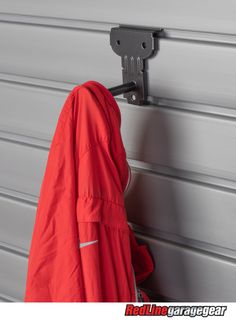 a red coat hanging on the side of a garage door