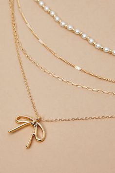 Add a dash of charm to your look with our super dainty and adorable necklace featuring a bow charm and delicate pearl detailing. This elegant accessory exudes timeless beauty, perfect for effortlessly elevating any ensemble with its whimsical and graceful allure. Bow Necklace, Accessories Jewelry Necklace, Birthday Wishlist, Elegant Accessories, Altar'd State, Sweater Sale, Gold Pearl, Timeless Beauty, Pearl Necklace