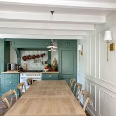 a large wooden table sitting in the middle of a kitchen next to a stove top oven