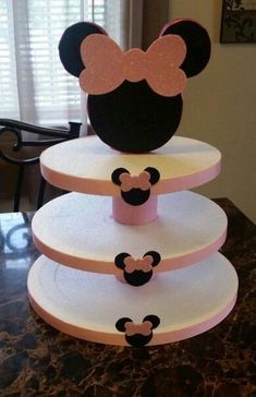 three tiered mickey mouse cake with pink and black ears on it's head