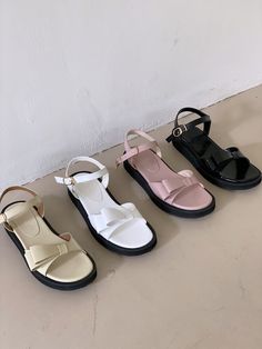 four different types of sandals are lined up on the floor