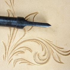 a pen sitting on top of a piece of paper next to a drawing with swirls