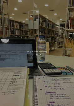 an open laptop computer sitting on top of a desk next to a calculator